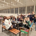 Large Group Of Alumni Sitting Around A Table Turned Toward The Camera