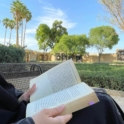 A person holding an open book in their lap