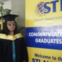 Maria stands next to a graduation banner