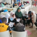 Participants sit in a circle engaging in group activity