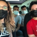 A group of four YES alumni sitting in a car with masks on