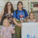 Rida at the airport standing next to her host mother and host sisters.