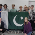 Hashir, YES student, holding a Pakistani flag and standing next to his classmates.