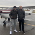 Wassy standing next to Mr. Loffler and a plane