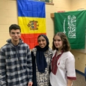 Seba From Saudi Arabia Poses With Two Classmates In Front Of Flags