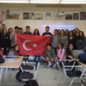 Verda holding Turkish flag with group of students in their Spanish class