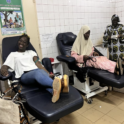 Two young people seated as they prepare to make a donation