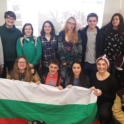 Vyara Nikolova and YES Alumni in group photo holding Bulgarian flag. 