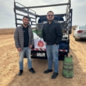Ahmad and Wasseem standing with a truck full of donations