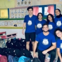YES alumni in blue t shirts with school bags