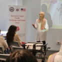 Young Woman In A Pink Hijab Standing In Front Of A Classroom Of People