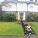 Yusr sits n the steps of her house with a dog
