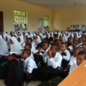 Around a hundred students wear uniforms in a classroom in Zanzibar