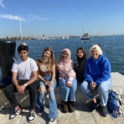 Muhammad smiling with friends on a dock at Boston Harbor