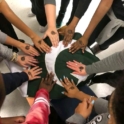 Different people's hands joined together over a Pakistani flag