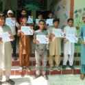 Aisha's students holding certificates in front of the classroom. 