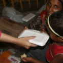 YES alumni handing a local family a container food