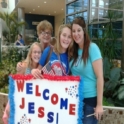 Host Family and Jess at the airport holding a "Welcome Jess" sign
