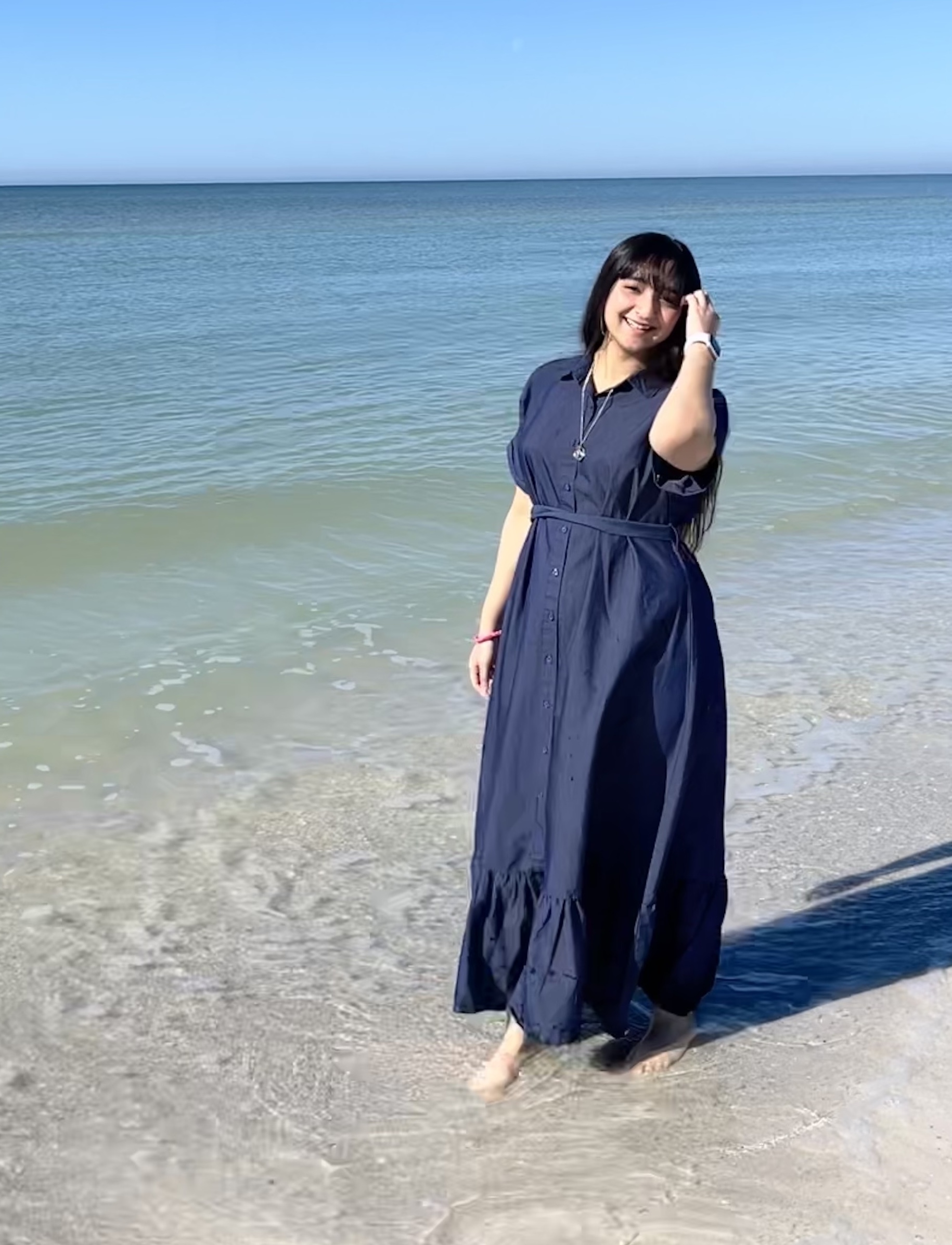 Mahnoor on the beach with her feet in the water