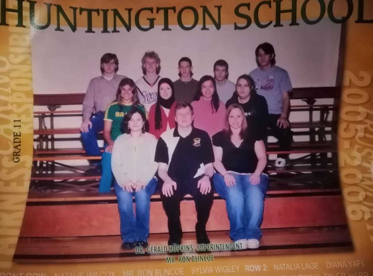 Photo of a group of students with teacher sitting on bleachers. "Huntington School" is written at the top of the photo.