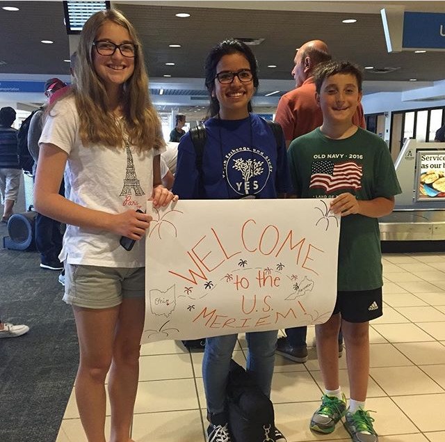 YES student, Meriem, meeting her host siblings for the first time at the airport